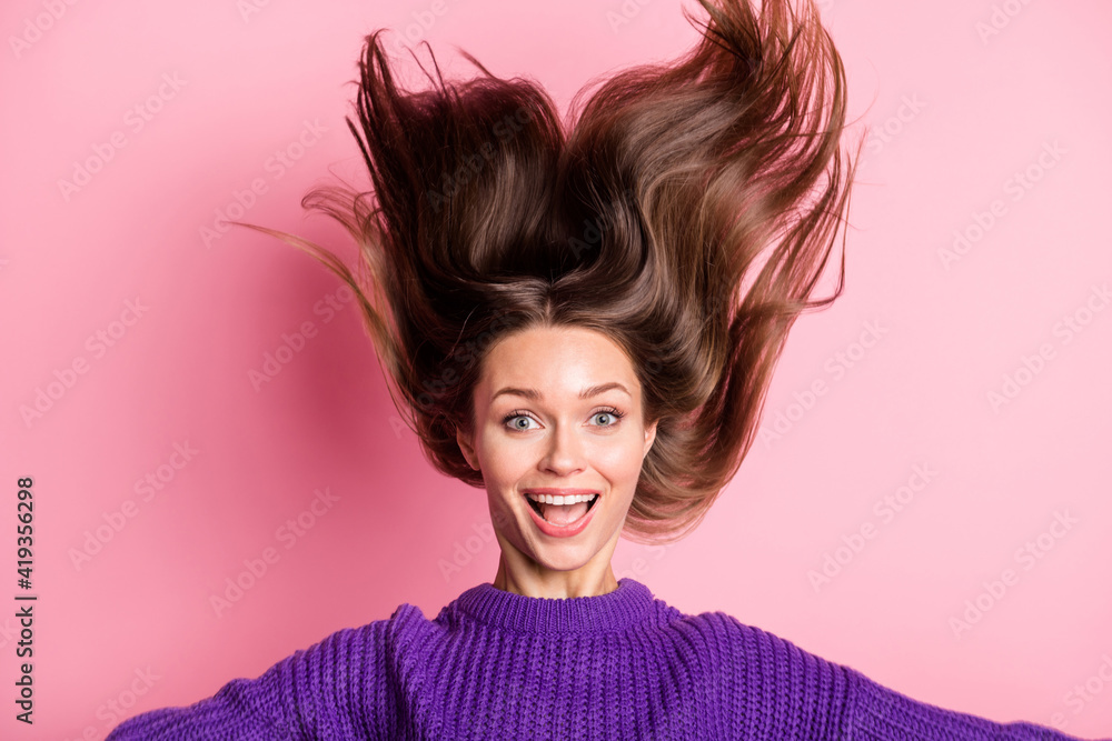 Portrait of astonished pretty lady open mouth hair flying wear purple pullover isolated on pink color background Portrait of astonished pretty lady open mouth hair flying wear purple pullover isolated on pink color background