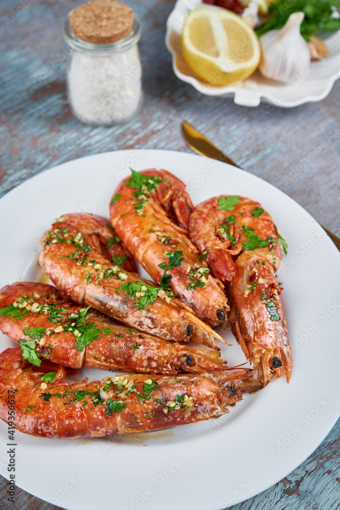 Grilled large queen shrimps with lemon and spices on the plate Grilled large queen shrimps with lemon and spices on the plate