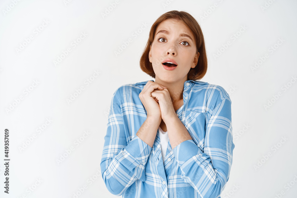 Portrait of fascinated girl gasping and looking captivated at something adorable, standing amazed in checked shirt on white background Portrait of fascinated girl gasping and looking captivated at something adorable, standing amazed in checked shirt on white background