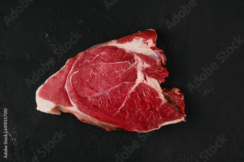 Overhead view of raw top round roast beef on dark background
