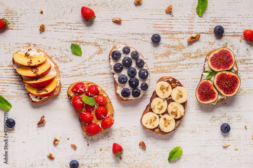 Homemade summer toast with cream cheese, nut butter and fruits and berries