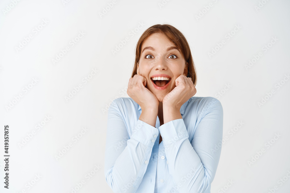 Portrait of excited young businesswoman gasping fascinated, looking with admiration and happiness, winning prize, standing on white background Portrait of excited young businesswoman gasping fascinated, looking with admiration and happiness, winning prize, standing on white background