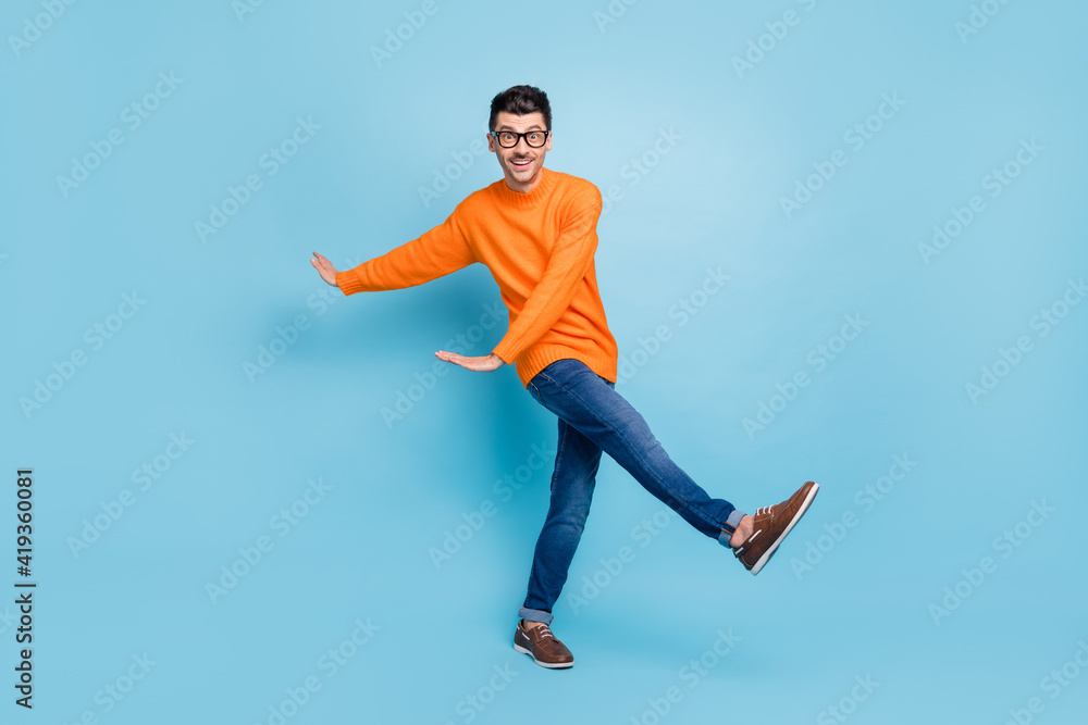 Full size photo of satisfied person dancing have fun toothy smile wear sweater isolated on blue color background Full size photo of satisfied person dancing have fun toothy smile wear sweater isolated on blue color background