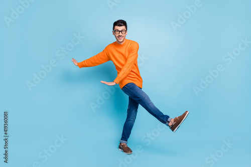 Full size photo of satisfied person dancing have fun toothy smile wear sweater isolated on blue color background