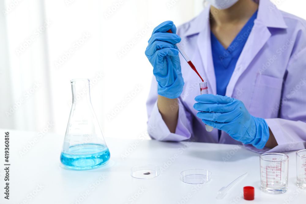 Scientist holding Coronavirus covid-19 infected blood sample tube DNA testing of the blood in the laboratory with blood sample collection tubes and syringe Coronavirus Covid-19 vaccine research. Scientist holding Coronavirus covid-19 infected blood sample tube DNA testing of the blood in the laboratory with blood sample collection tubes and syringe Coronavirus Covid-19 vaccine research.