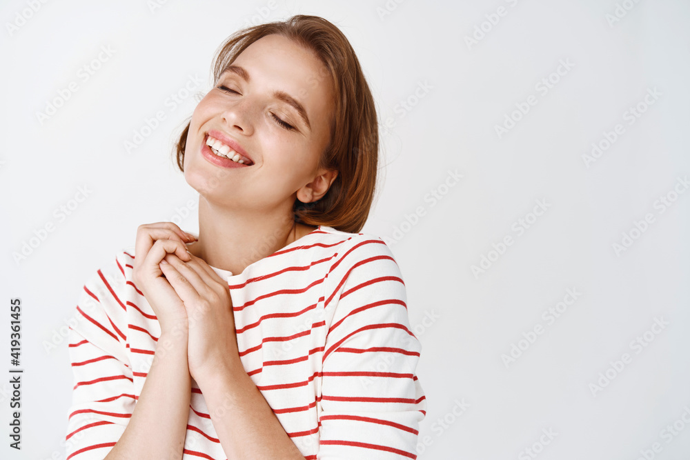 Beauty and skin care. Happy young woman with natural light make-up, short hair, dreaming about something sweet, smile tenderly and close eyes, white background Beauty and skin care. Happy young woman with natural light make-up, short hair, dreaming about something sweet, smile tenderly and close eyes, white background