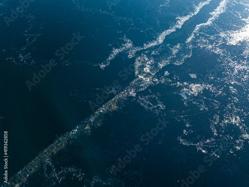 Frosty pattern on the river. Aerial drone view. Sunny winter day, thin ice on the river. © Sergey