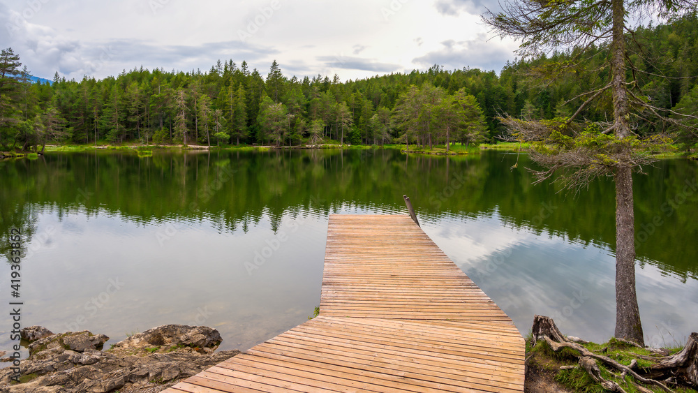 beautiful view of a forest lake with wooden pier Möserer See Austria beautiful view of a forest lake with wooden pier Möserer See Austria