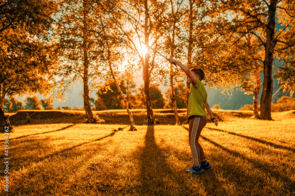 Fototapeta premium one young boy playing in badminton outdoors