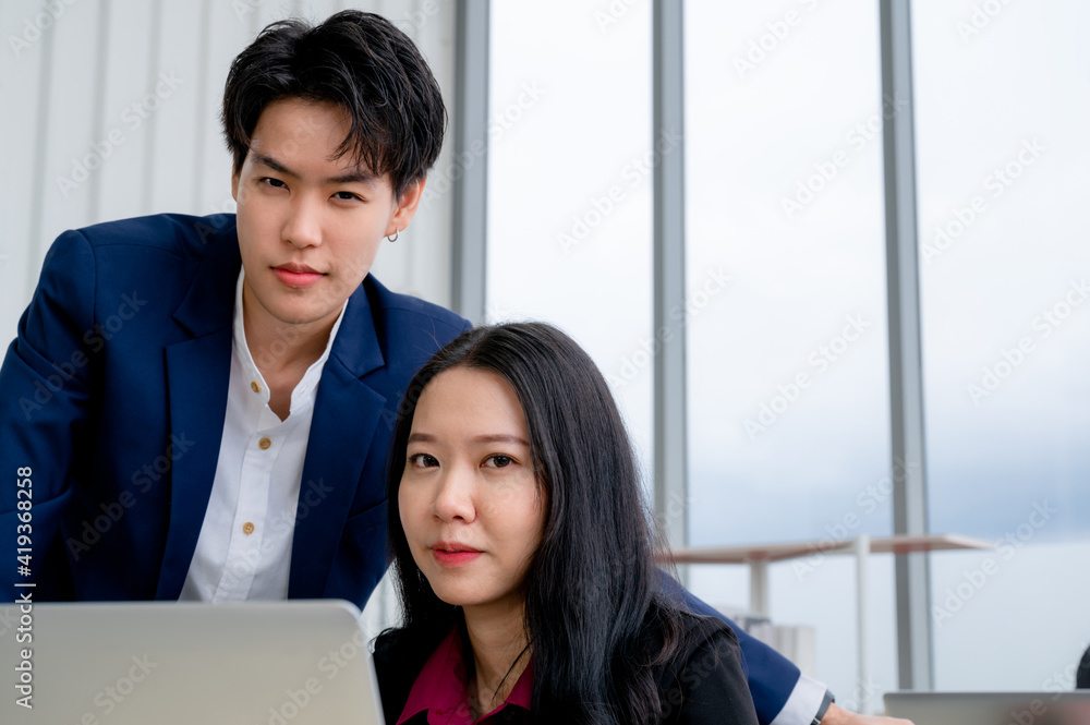 Confident and smart beautiful businesswoman in formal attire stands in the office. With a group of friends and laptop in the background. A cheerful idea to work within the workspace. Confident and smart beautiful businesswoman in formal attire stands in the office. With a group of friends and laptop in the background. A cheerful idea to work within the workspace.