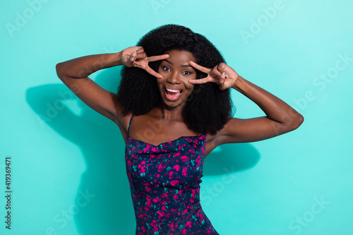 Photo portrait woman in dress funky showing v-sign gesture smiling isolated bright teal color background