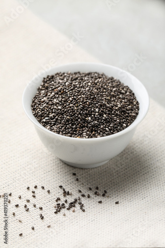 Bowl with chia seeds on light grey table
