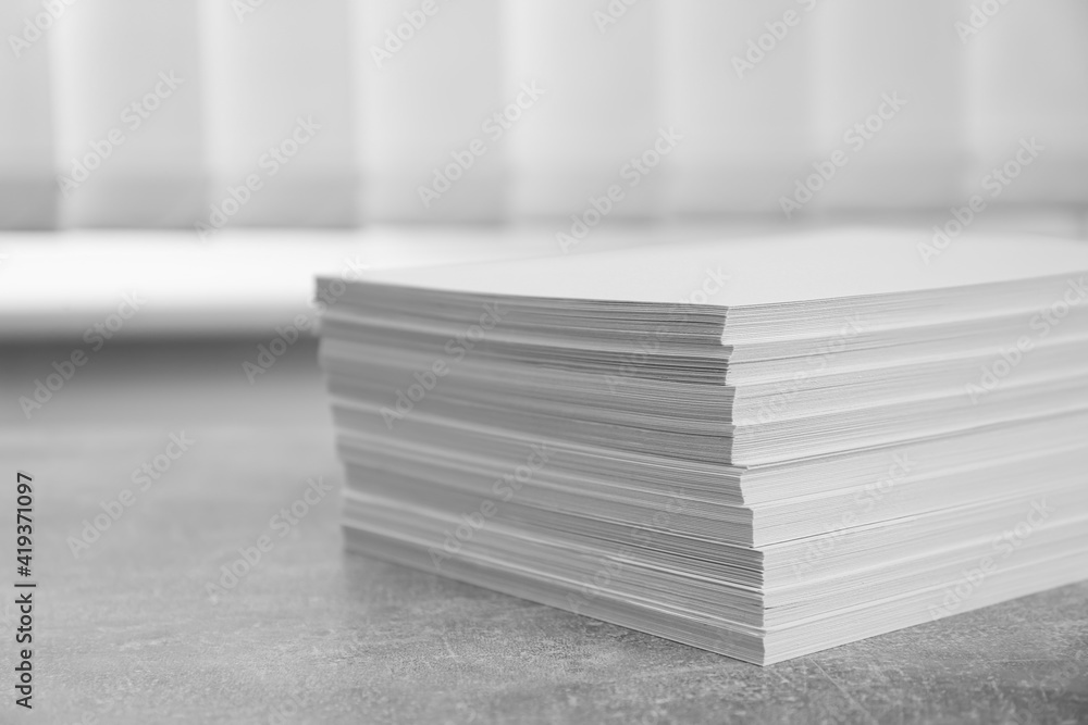 Stack of paper sheets on grey table, closeup Stack of paper sheets on grey table, closeup
