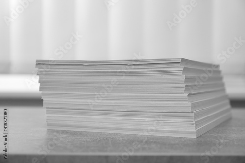 Stack of paper sheets on grey table, closeup