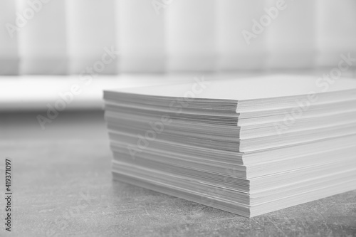 Stack of paper sheets on grey table, closeup