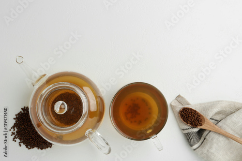 Buckwheat tea and granules on white background, flat lay. Space for text photo