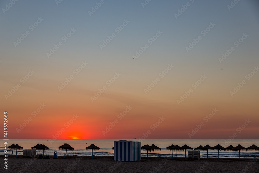 Obraz premium sunrise with beautiful colors at malvarosa beach of the City of valencia, costa blanca, spain