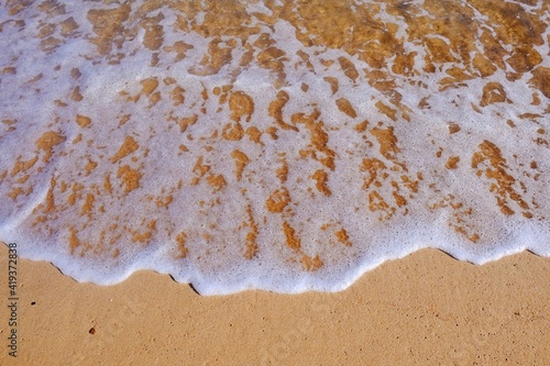 Sand beach with white sea soft foam wave on top view in thailand for assembling an article about travel in summer holiday or ocean sand beach coast nature.