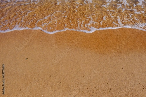 Sand beach with white sea soft foam wave on top view in thailand for assembling an article about travel in summer holiday or ocean sand beach coast nature.