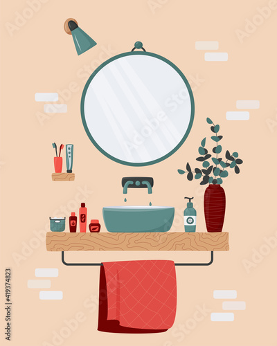 Cozy bathroom interior. Blue sink on wood counter with a large round mirror hanging above it. Vase with eucalyptus branches. Toothbrush, body care cosmetics, towel