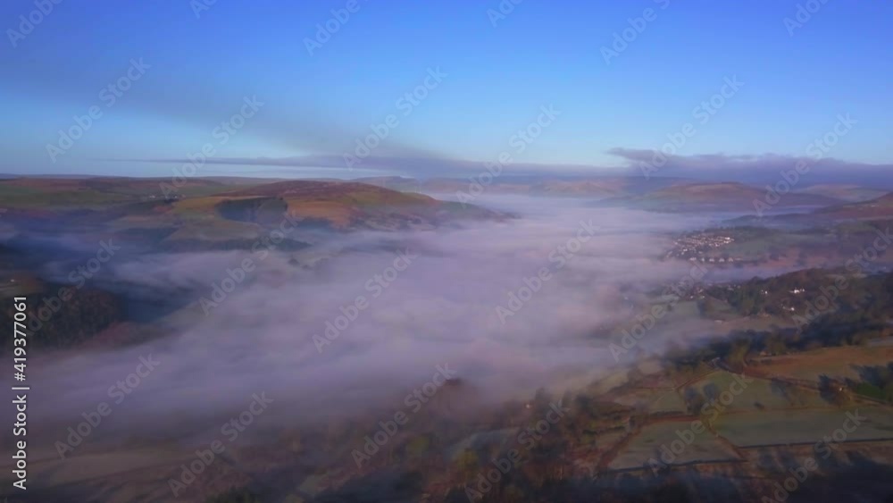 Drone over countryside with blue sky and low fog Drone over countryside with blue sky and low fog