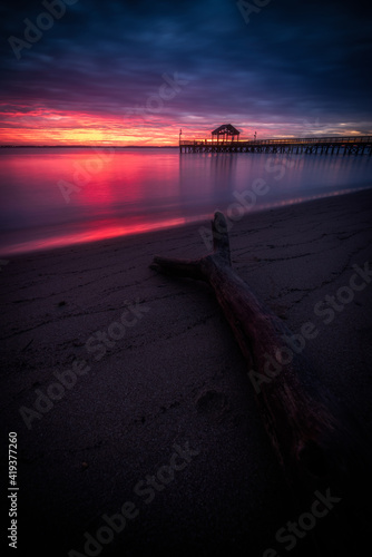 A piece of driftwood on the beach at Leesylvania State Park in Virginia along the Potomac River at sunrise.