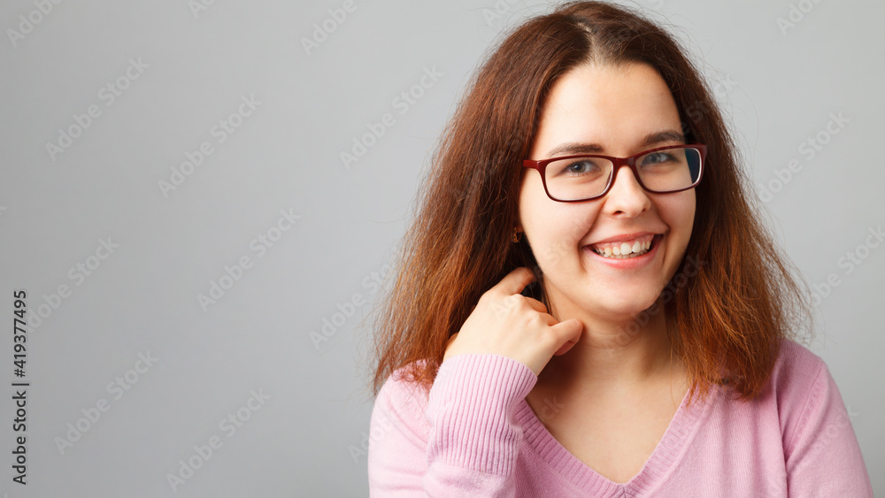 Young redhead woman wearing glasses. Head and shoulders portrait