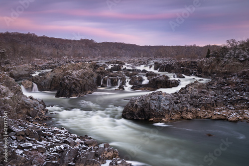 A Winter morning sunrise at Great Falls Park with the rocks covered in a dusting of snow.