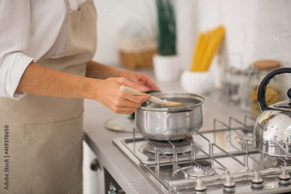 Woman in apron cooking in the kitchen