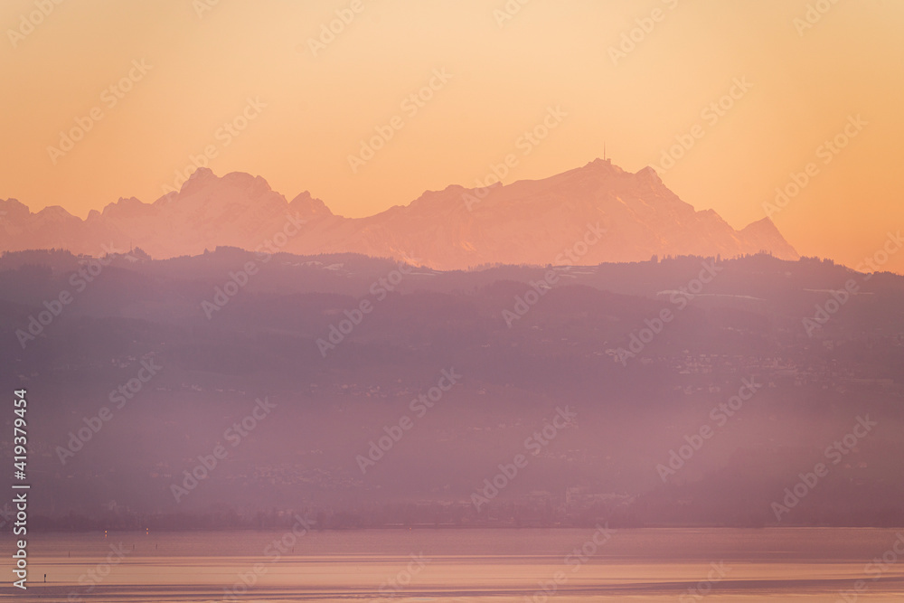 Sonnenuntegang und Abendstimmng am Bodensee; Blick vom Hoyerberg in Lindau auf den Bodensee, Appenzeller Hügelzug und das Alpsteinmassiv mit Säntis und Altmann im rotglänzenden Abendlicht