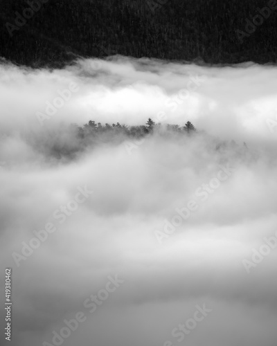 A small ridge line of trees pokes through a sea of fog on a weather filled Winter day in Shenandoah National Park.