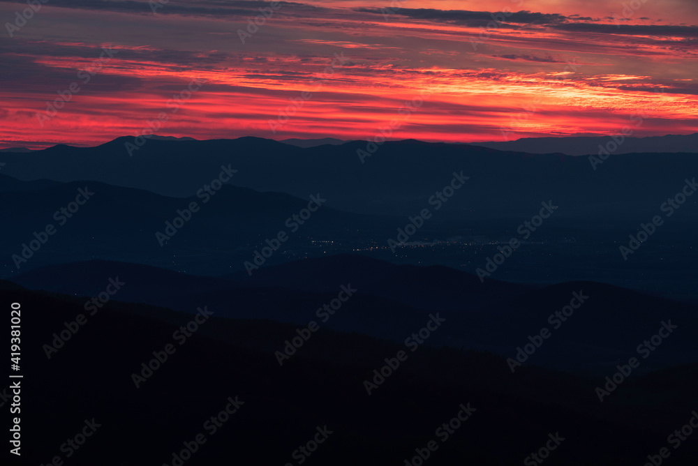 Neon like reds and oranges at sunset over the darkened valleys of Shenandoah National Park. Neon like reds and oranges at sunset over the darkened valleys of Shenandoah National Park.