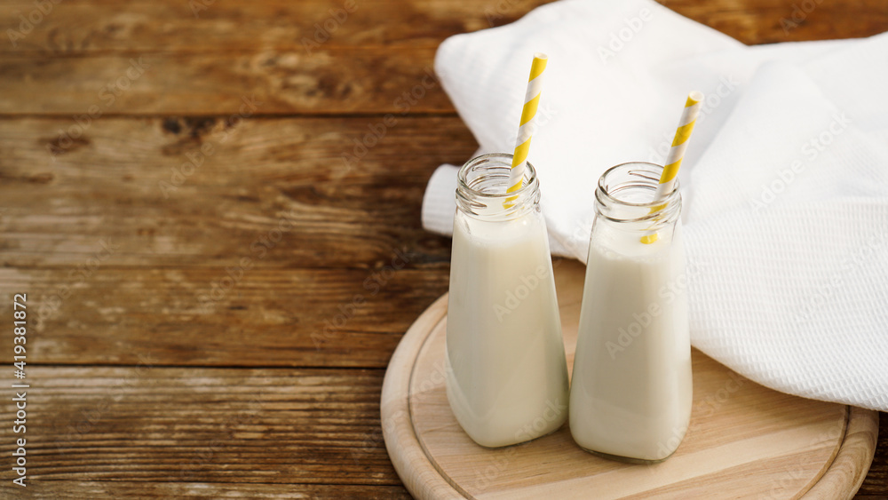 Two bottles of organic rustic milk on wooden table Two bottles of organic rustic milk on wooden table