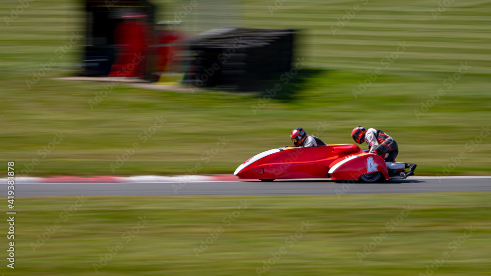 A panning shot of a racing sidecar as it corners on a track.