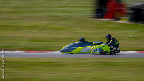 A panning shot of a racing sidecar as it corners on a track.