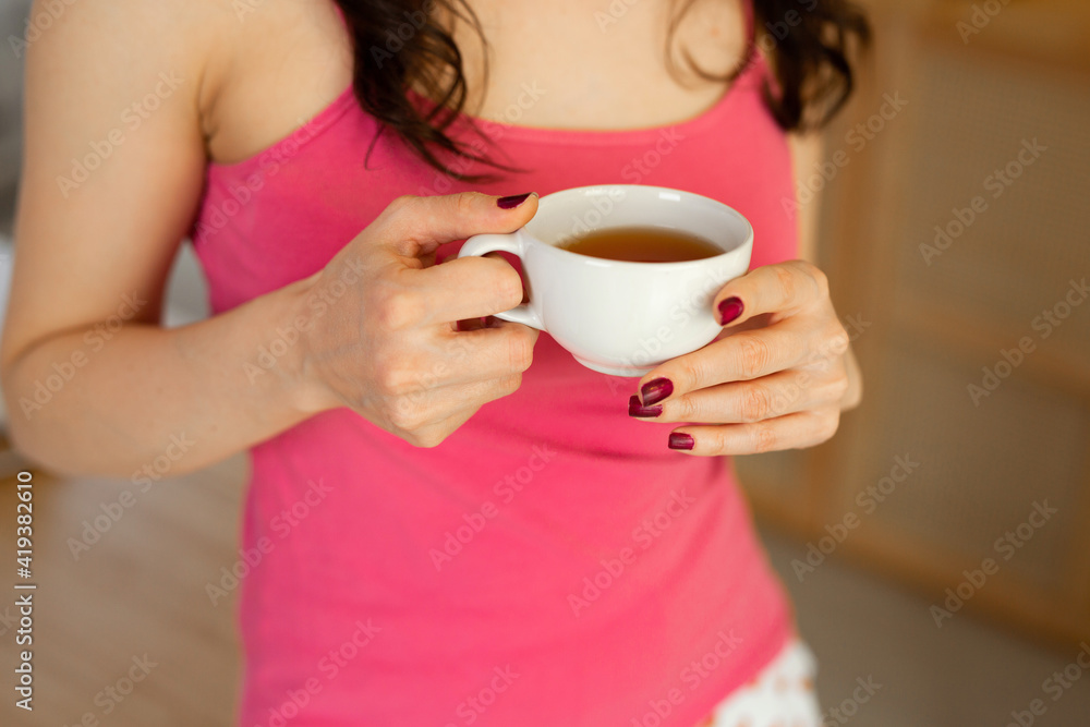 a mug of tea in the hands of a young woman a mug of tea in the hands of a young woman