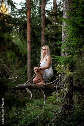 blonde girl in a white dress in the woods, selective focus