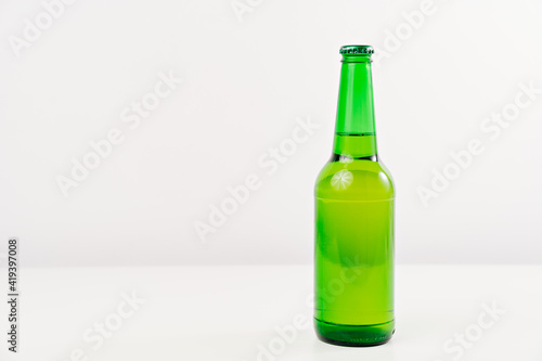 green glass bottle on a white background. condensate