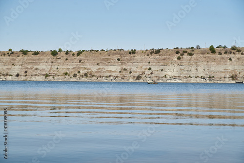 Scenic view over wide river and it s bank. Beautiful natural countryside landscape with blue sunny sky. Summer getaway vacation into isolated places. Calm water - perfect for meditation.