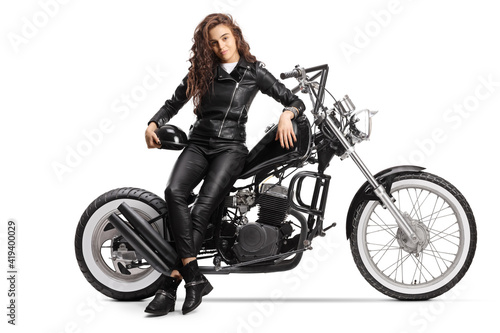Young woman with a long curly hair sitting on a custom chopper motorbike