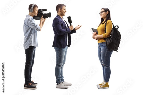Full length profile shot of a reporter interviewing a female student and cameraman recording