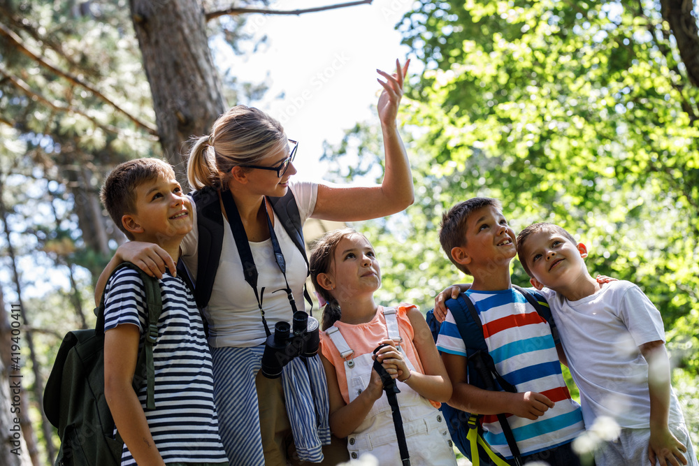 Group of children hiking in forest with they teacher.They learning ...