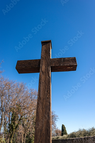 Closeup of a wooden Christian cross on a clear blue sky in a rural scene. Garda, Verona province, Veneto, Italy, Europe.