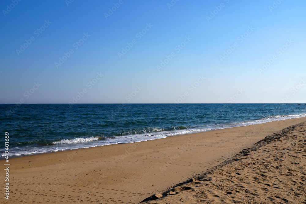 empty sandy beach, sea horizon and clear sky