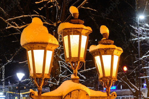 The classic old street lamps during the snowfall in European city.