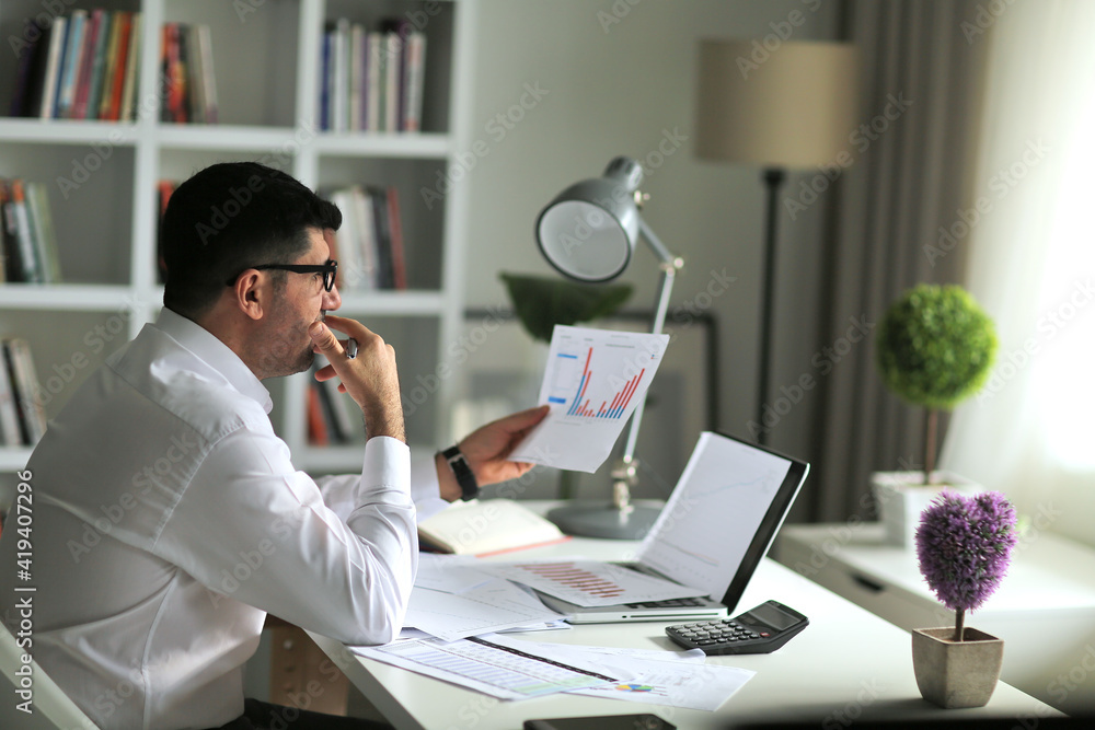 Thoughtful businessman analyzing sales data and economic growth graph chart. Business strategy Thoughtful businessman analyzing sales data and economic growth graph chart. Business strategy