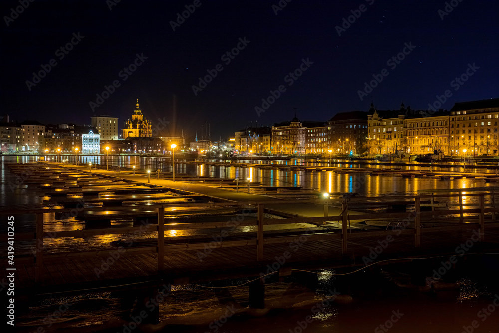 Finland, Helsinki, 03 March 2021.  Night panorama of Helsinki, a view of the Katajanokka and Krununhakka districts in the foreground the Gulf of Finland and boat docks