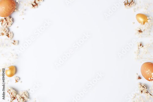 Easter eggs with flowers on white background. Flat lay, copy space.