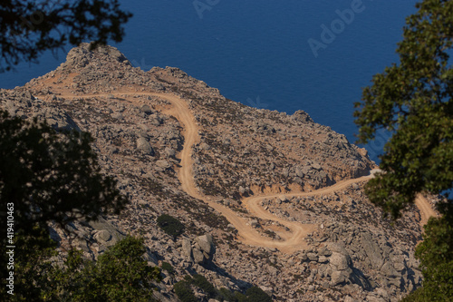 Adventurous trip on a gravel road through barren mountain slopes of Ikaria island.  photo