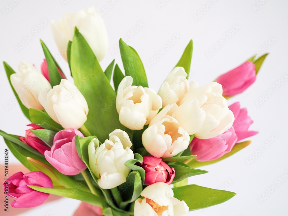 Fototapeta premium Hand of the man holding beautiful bouquet of tulips. Love and Relationship. Celebrating anniversary, Valentine's Day, Women's Day, Mother's Day, Wedding. Flowers to Minimalistic concept. Copy space